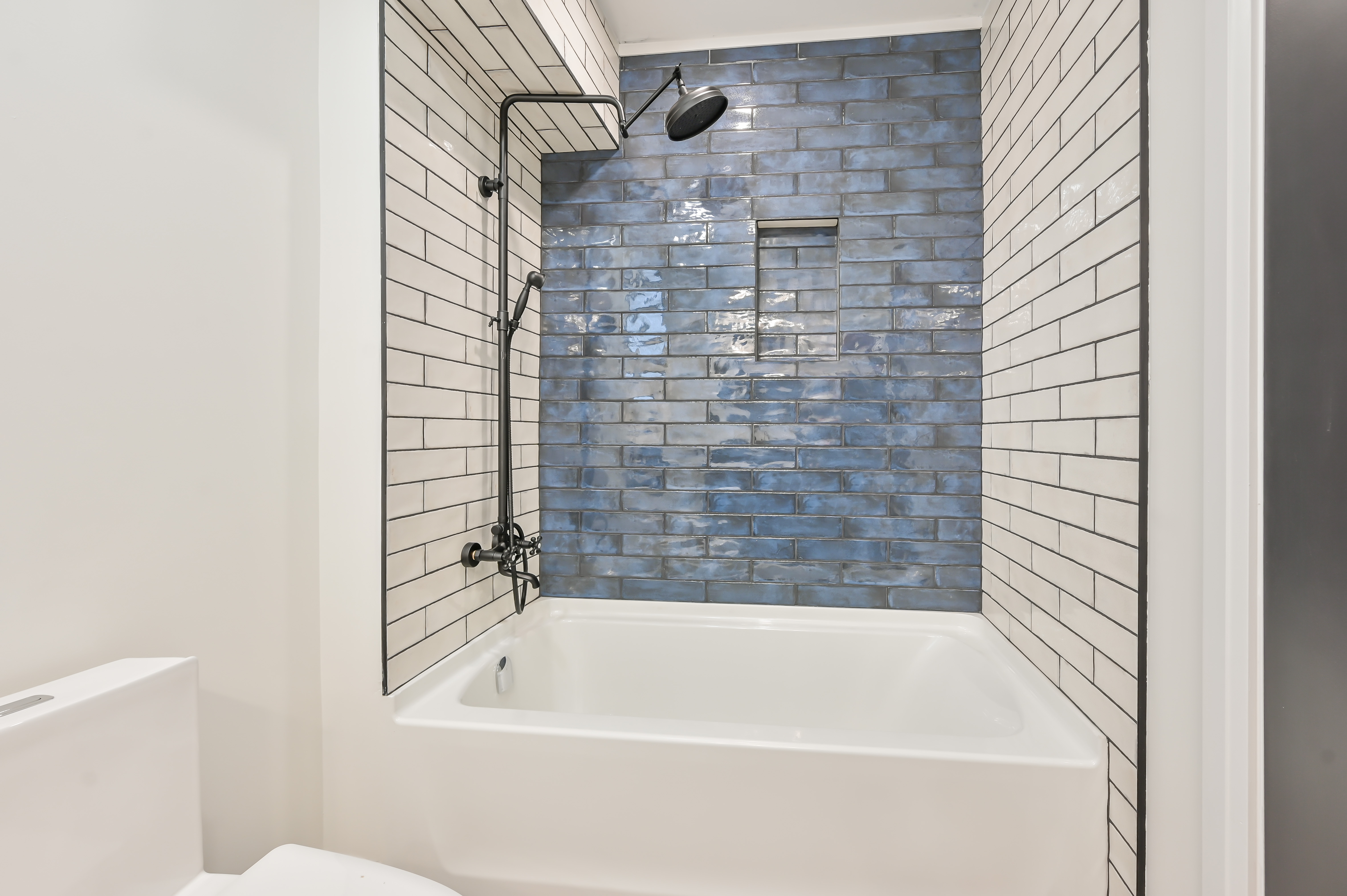 Beautifully finished bathroom with striking blue accent tile and clean white subway tile — premium portfolio shot with strong material contrast — Kron, Hamilton | MTC Renovations